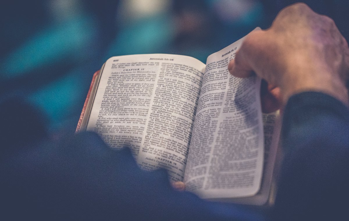 Hands holding an open Bible