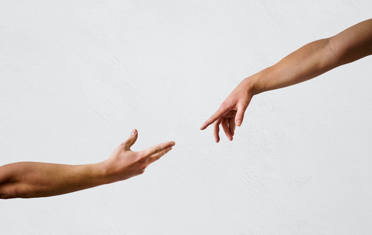 Two hands reaching out towards one another
